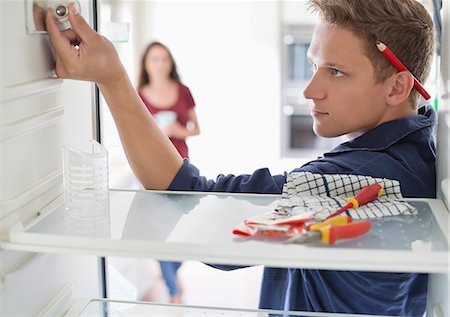 Electrician working on fridge in home Foto de stock - Sin royalties Premium, Código: 6113-06753284