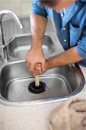 Plumber unclogging kitchen sink Foto de stock - Sin royalties Premium, Código: 6113-06753288