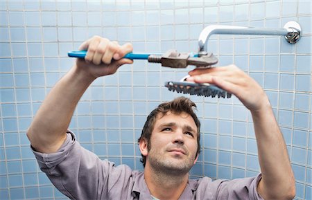 simsearch:6113-06753307,k - Plumber working on shower head in bathroom Stock Photo - Premium Royalty-Free, Code: 6113-06753200