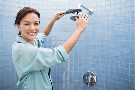 plumbing repairs - Female plumber working on shower head in bathroom Stock Photo - Premium Royalty-Free, Code: 6113-06753214