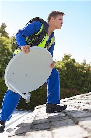 simsearch:6113-06753315,k - Worker installing satellite dish on roof Fotografie stock - Premium Royalty-Free, Codice: 6113-06753343