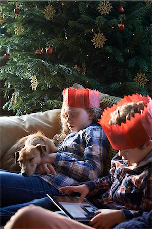 family celebration - Children in paper crowns relaxing on sofa Stock Photo - Premium Royalty-Free, Code: 6113-06753393