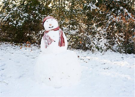 Snowman wearing hat and scarf Foto de stock - Royalty Free Premium, Número: 6113-06753398