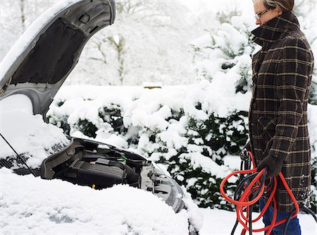 problem - Woman working on broken down car in snow Stock Photo - Premium Royalty-Free, Code: 6113-06753399