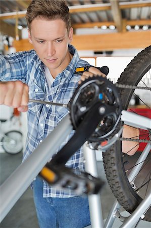 simsearch:6113-06753249,k - Man working on bicycle in shop Stock Photo - Premium Royalty-Free, Code: 6113-06753303