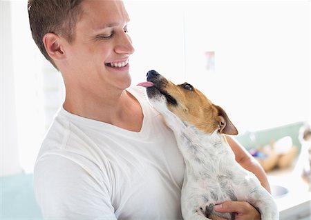 photos of men and dogs - Smiling man holding dog Stock Photo - Premium Royalty-Free, Code: 6113-06753312