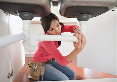 simsearch:6113-06753252,k - Woman working on pipes under kitchen sink Stock Photo - Premium Royalty-Free, Code: 6113-06753325