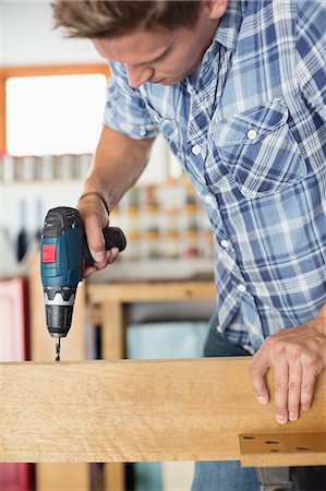 squat (exercise) - Man working in workshop Stock Photo - Premium Royalty-Free, Code: 6113-06753336