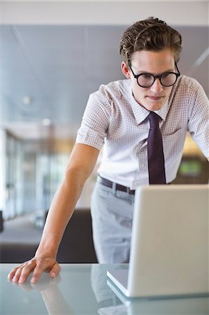 Businessman working on laptop at desk Stock Photo - Premium Royalty-Free, Code: 6113-06753464