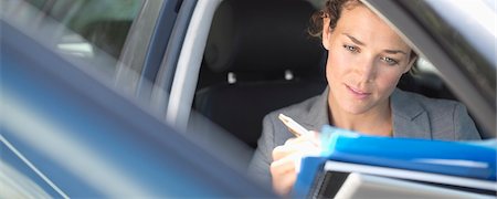 reading - Businesswoman working in car Foto de stock - Sin royalties Premium, Código: 6113-06753415