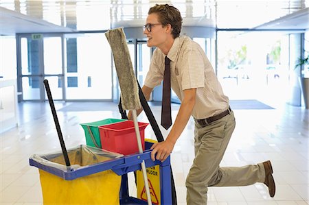 scopa - Businessman pushing cleaning cart in office Fotografie stock - Premium Royalty-Free, Codice: 6113-06753423