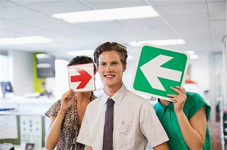 Business people holding arrows in office Stock Photo - Premium Royalty-Free, Code: 6113-06753436