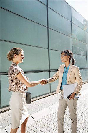 smile and greeting - Businesswomen shaking hands on city street Stock Photo - Premium Royalty-Free, Code: 6113-06753551