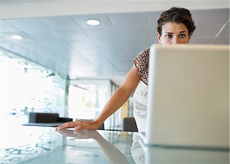 Businesswoman working on laptop at desk Stock Photo - Premium Royalty-Free, Code: 6113-06753556