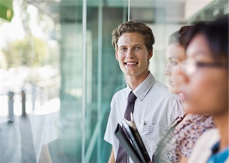 Businessman smiling at office window Stock Photo - Premium Royalty-Free, Code: 6113-06753558