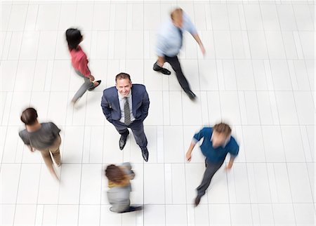 directly above woman - Businessman standing in busy office hallway Photographie de stock - Premium Libres de Droits, Code: 6113-06753577