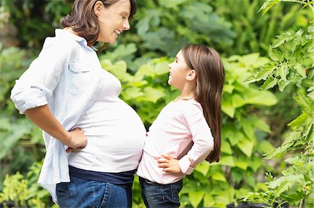 stomach (upper abdomen) - Girl bumping pregnant mother's belly Stock Photo - Premium Royalty-Free, Code: 6113-06753594