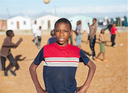 fraternidad - Boy standing in dirt field Foto de stock - Sin royalties Premium, Código: 6113-06753773