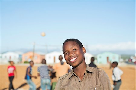 simsearch:6113-06753787,k - Boy smiling in dirt field Photographie de stock - Premium Libres de Droits, Code: 6113-06753772