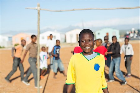 soccer portrait boys - Boy smiling in dirt field Stock Photo - Premium Royalty-Free, Code: 6113-06753774