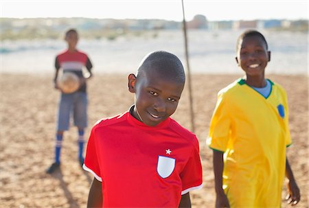 soccer portrait boys - Boys smiling in dirt field Stock Photo - Premium Royalty-Free, Code: 6113-06753778