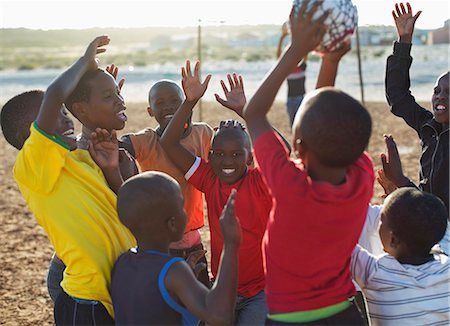 energetic kids playing sports - Boys playing soccer together in dirt field Stock Photo - Premium Royalty-Free, Code: 6113-06753783