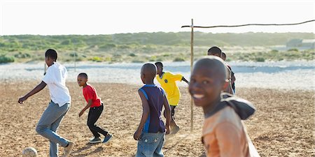 simsearch:6113-06753824,k - Boys playing soccer together in dirt field Stock Photo - Premium Royalty-Free, Code: 6113-06753780