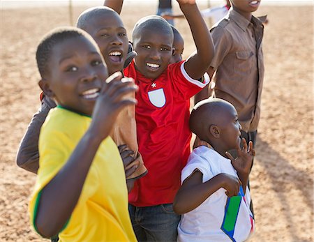 Boys playing together in dirt field Foto de stock - Sin royalties Premium, Código: 6113-06753787