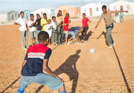 soccer defence - Boys playing soccer together in dirt field Stock Photo - Premium Royalty-Free, Code: 6113-06753799