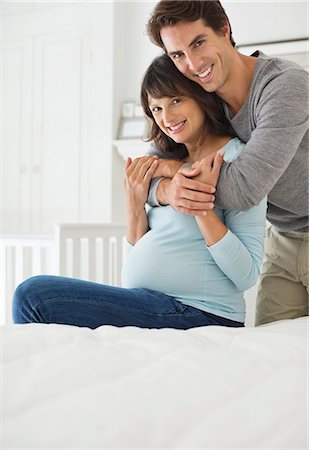 esperanzas - Man hugging pregnant girlfriend on bed Foto de stock - Sin royalties Premium, Código: 6113-06753713