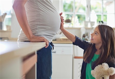 Girl holding pregnant mother's belly Foto de stock - Sin royalties Premium, Código: 6113-06753714