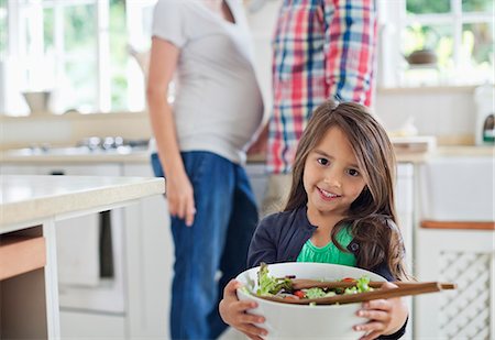 Girl holding bowl of salad in kitchen Stock Photo - Premium Royalty-Free, Code: 6113-06753726