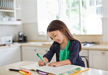 Girl using coloring book in kitchen Stock Photo - Premium Royalty-Free, Code: 6113-06753733