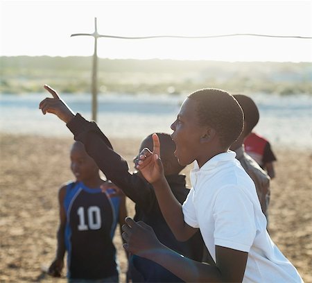 simsearch:6113-06753786,k - Boys shouting together in dirt field Stock Photo - Premium Royalty-Free, Code: 6113-06753800