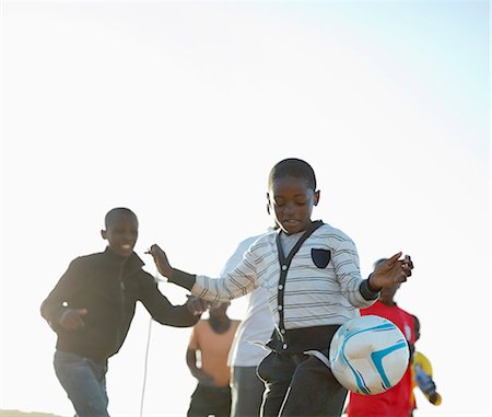 simsearch:6113-06753824,k - Boys playing soccer together in dirt field Stock Photo - Premium Royalty-Free, Code: 6113-06753822