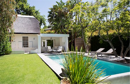 Lawn chairs and swimming pool in backyard Photographie de stock - Premium Libres de Droits, Code: 6113-06753947