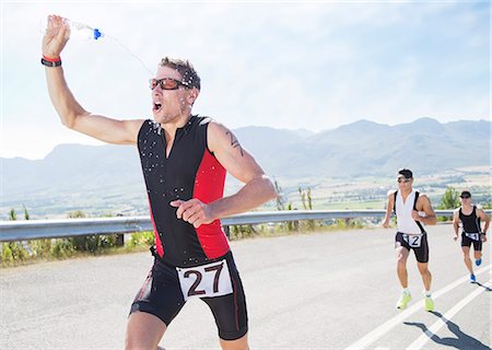 Runner spraying himself with water in race Stock Photo - Premium Royalty-Free, Code: 6113-06753962