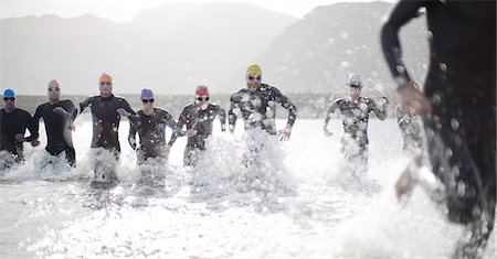 simsearch:6113-06754059,k - Triathletes in wetsuits running in waves Photographie de stock - Premium Libres de Droits, Code: 6113-06753986