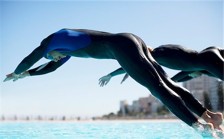 Triathletes diving into swimming pool Stock Photo - Premium Royalty-Free, Code: 6113-06754042