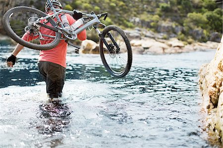 Man carrying mountain bike in river Foto de stock - Sin royalties Premium, Código: 6113-06754090