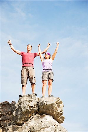 simsearch:6113-06754093,k - Climbers cheering on rocky hilltop Photographie de stock - Premium Libres de Droits, Code: 6113-06754094