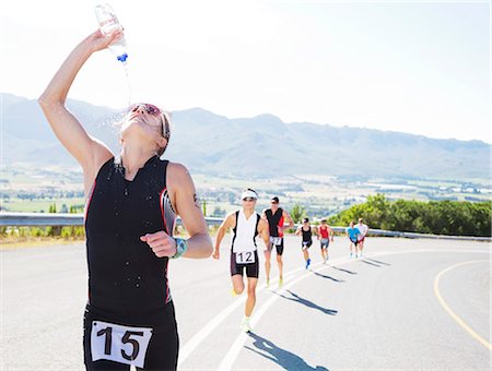 Runner spraying water on rural road Stock Photo - Premium Royalty-Free, Code: 6113-06754031