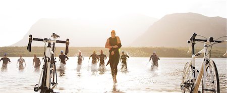 people on racing bikes - Triathletes running to bicycles on beach Stock Photo - Premium Royalty-Free, Code: 6113-06754035