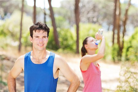 focus on foreground forest - Couple resting during workout outdoors Stock Photo - Premium Royalty-Free, Code: 6113-06754157