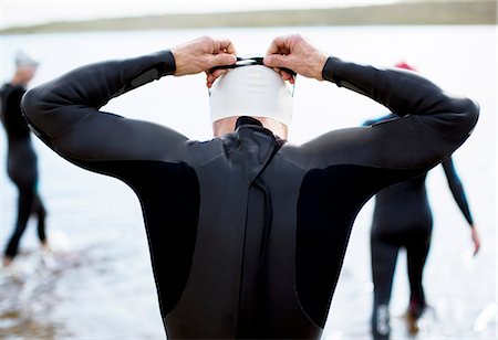 Triathlete adjusting goggles at start of race Photographie de stock - Premium Libres de Droits, Code: 6113-06754119