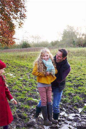 Father and daughter laughing in muddy field Photographie de stock - Premium Libres de Droits, Code: 6113-06720247