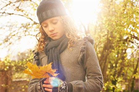Girl carrying autumn leaf outdoors Stock Photo - Premium Royalty-Free, Code: 6113-06720253