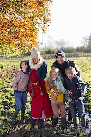 simsearch:6113-06720270,k - Family smiling together in muddy field Photographie de stock - Premium Libres de Droits, Code: 6113-06720274