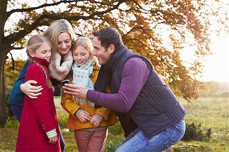 fall mother - Family using cell phone together outdoors Stock Photo - Premium Royalty-Free, Code: 6113-06720276