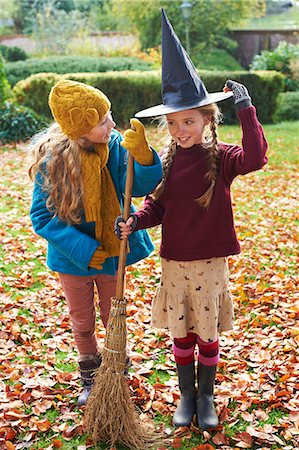 scopa - Girls playing with witch's hat and broom outdoors Fotografie stock - Premium Royalty-Free, Codice: 6113-06720293